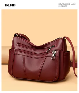 Detail view of burgundy soft faux leather bag with functional multi-zipper compartments