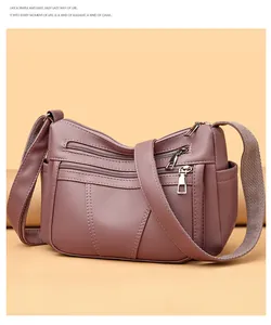 Detail of lychee pattern leather and multiple zipper pockets on soft textured shoulder bag