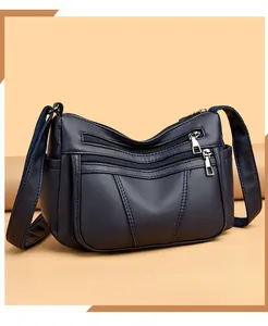 Detail of soft blue leather shoulder bag showing multiple zipper pockets and texture