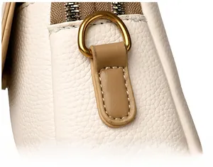 Gros plan sur cuir grainé blanc avec anneau en D doré et coutures beiges de précision