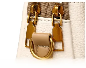 Détails du cuir grainé blanc et de la fermeture éclair dorée sur le sac bandoulière