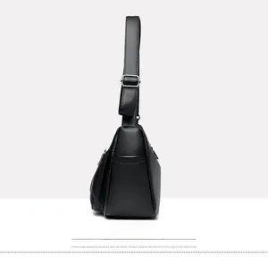 Side view of black textured leather bag showing depth and adjustable silver buckle strap