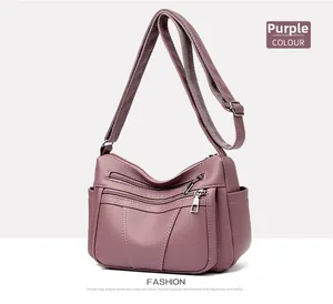Detail of purple soft leather crossbody bag with multiple zippers and wide strap