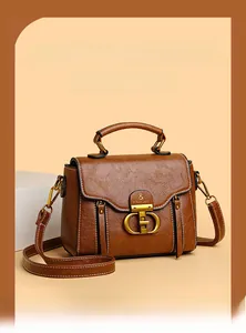 Detail of vintage brown textured handbag showing the retro gold dual-D metal buckle hardware