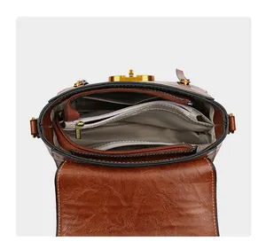 Detailed view of brown crossbody bag interior with multiple compartments and gold hardware