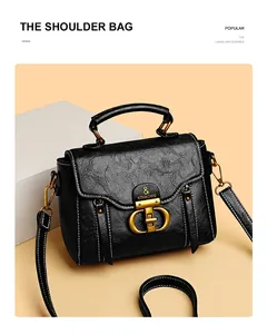 Detail of black leather shoulder bag with vintage gold hardware and white stitching