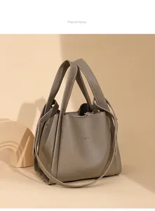Detalle de la textura de cuero gris topo y las asas reforzadas de este bolso cubo