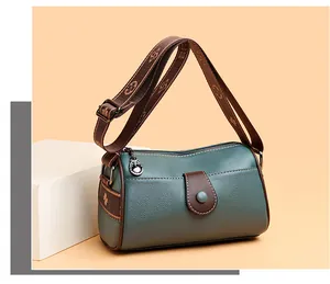 Détail du sac bandoulière en cuir grainé vert avec sangle en tissu à motif floral