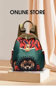 Detalle de mini mochila bicolor con estampado de tigre, cierre metálico y correas de letras