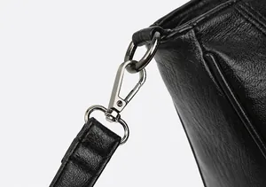 Detailaufnahme des strukturierten silbernen Metallhakens an der schwarzen Ledertasche