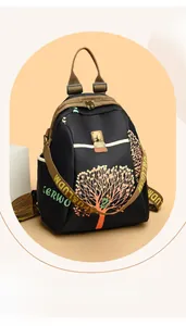 Detail of multi-compartment travel backpack with colorful tree pattern and metal buckles