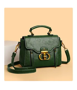 Close-up of dark green handbag with wrinkled texture and antique gold metal clasp