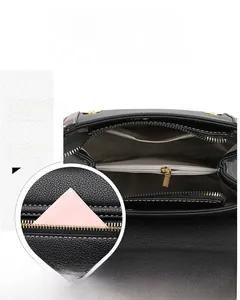 Detailed interior view of black crossbody bag showing multiple compartments and white stitching