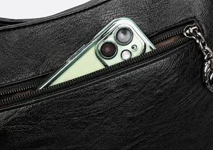 Nahaufnahme der hinteren Reißverschlusstasche an einer schwarzen Leder-Umhängetasche