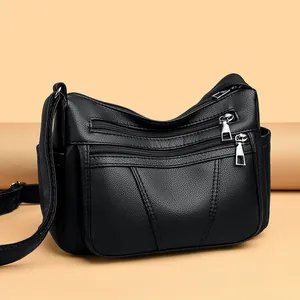 Black pebbled faux leather crossbody bag with multiple front zipper pockets and side slots