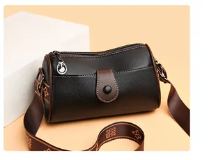 Vue détaillée du cuir marron foncé à grain de litchi et du pendentif de marque argenté