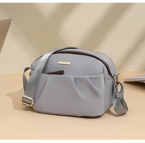 Detail view of water-resistant light purple crossbody bag with golden hardware and strap