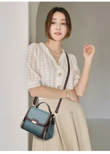 Close-up of litchi pattern leather bag with top handle and dark brown edge paint