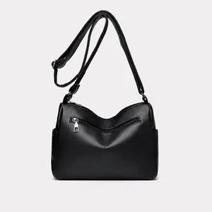 Achteraanzicht van zwarte lederen crossbodytas met zilveren ritsvak en schouderband