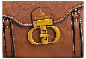 Close-up of vintage gold CD buckle and litchi texture on brown leather handbag