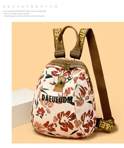 Close-up of floral print backpack with gold metal buckles and branded woven straps