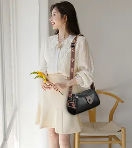 Gros plan d'un sac bandoulière en cuir noir avec une large sangle à motifs tendance
