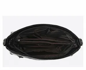 Detailed interior of large black soft leather handbag showing multiple storage compartments