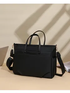 Detail of black laptop tote bag featuring gold hardware and adjustable wide shoulder strap