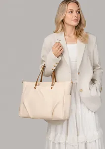 Detail of stylish cream laptop tote bag featuring brown handles and pleated texture design