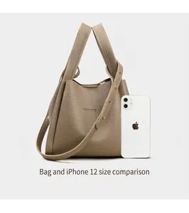 Comparación de tamaño entre el bolso tipo cubo de cuero y un iPhone 12