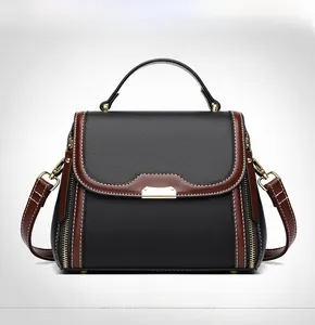 Detail of black lychee leather bag with brown trim and contrasting white stitching