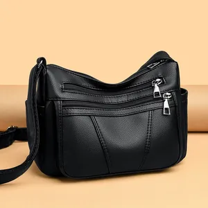Klassische schwarze Umhängetasche aus weichem Leder mit Reißverschlüssen und Silberdeko