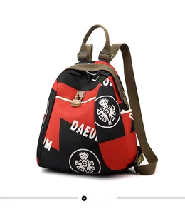 Détail du sac à dos imperméable rouge et noir avec imprimés blancs et boucle argentée