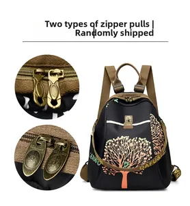Detail of metal zipper pulls with sea lion logo on a black nylon commuter backpack