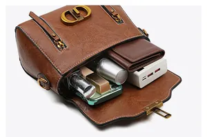 Interior storage view of brown retro shoulder bag with golden CD buckle and daily essentials