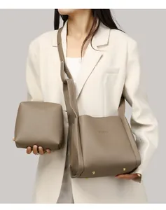 Detalle de bolso cubo de cuero topo con tachuelas doradas y estuche a juego