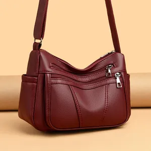 Schultertasche aus weinrotem Kunstleder mit Litschi-Struktur und Reißverschlusstaschen