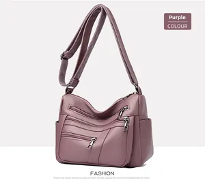 Detail view of purple soft leather crossbody bag showing multiple pockets and pebbled texture