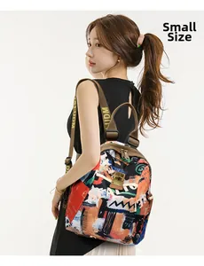 Detail view of small canvas backpack featuring abstract graffiti print and woven straps