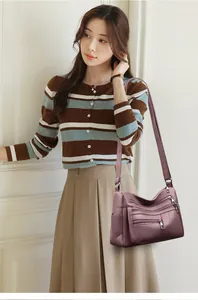 Close-up of purple faux leather crossbody bag with multiple zippers and pebble texture