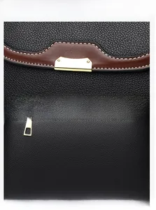 Detailed presentation of black litchi grain leather bag with gold buckle and stitching
