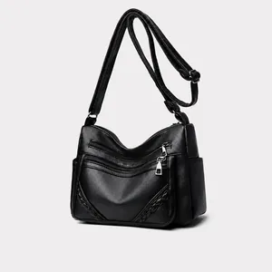Detail van zwarte crossbodytas van imitatieleer met meerdere handige ritsvakken