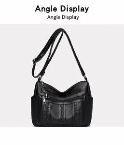 Detalle de bolso bandolera negro con múltiples cremalleras y correas tejidas decorativas