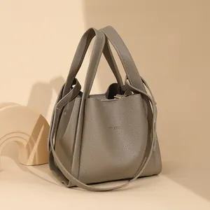 Bolso cubo minimalista taupe en cuero granulado con asas dobles y correa larga de hombro