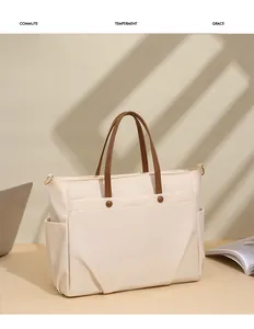 Detail of beige nylon tote bag with leather straps featuring snap front pocket for commute