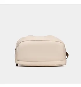 Detailed bottom view of a light cream oxford fabric crossbody bag with smooth stitching