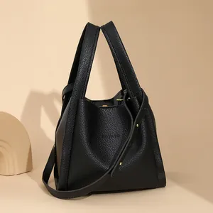Bolso cubo minimalista de cuero negro con patrón de lichi y correa de hombro ajustable