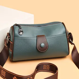 Sac Boston vert en cuir litchi avec bordures marron et bandoulière tissée à motifs