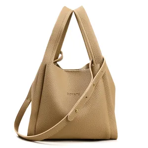 Bolso tipo cubo de cuero caqui con patrón de lichi y correa ajustable elegante
