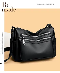 Détail du sac bandoulière en cuir grainé noir avec deux fermetures éclair argentées